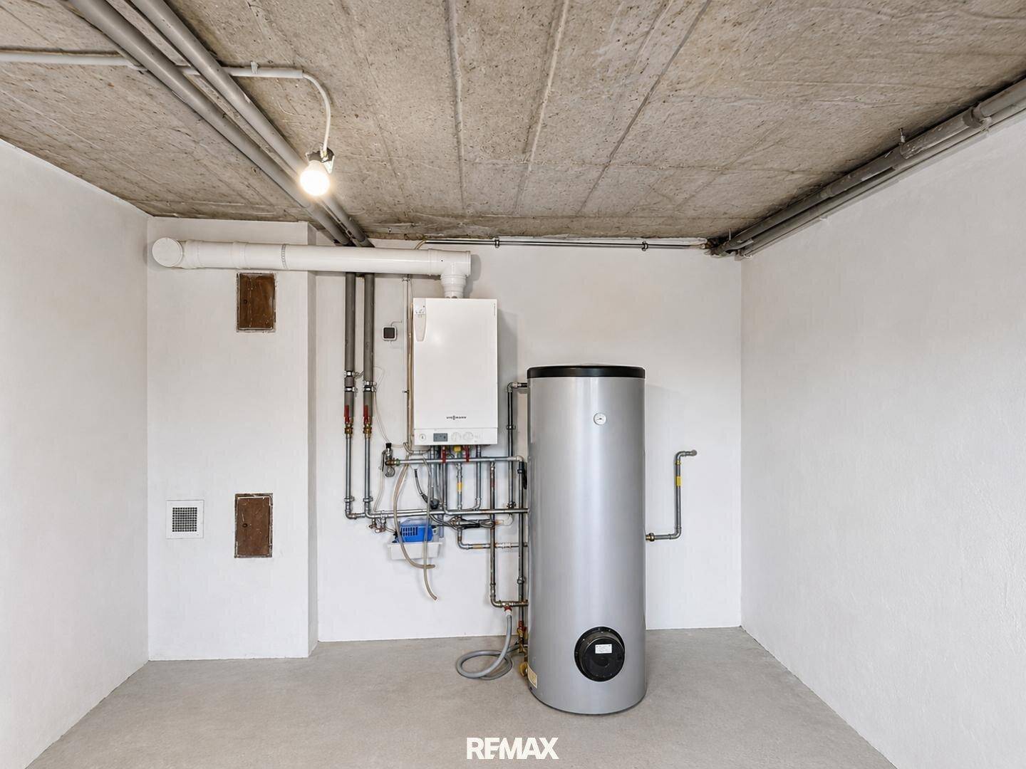 Detailansicht der Heizungsanlage und des Warmwasserspeichers im Kellergeschoss.