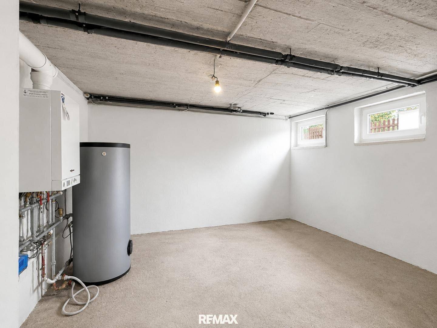 Heizraum im Keller mit moderner Heizungsanlage und Warmwasserspeicher in gutem Zustand.