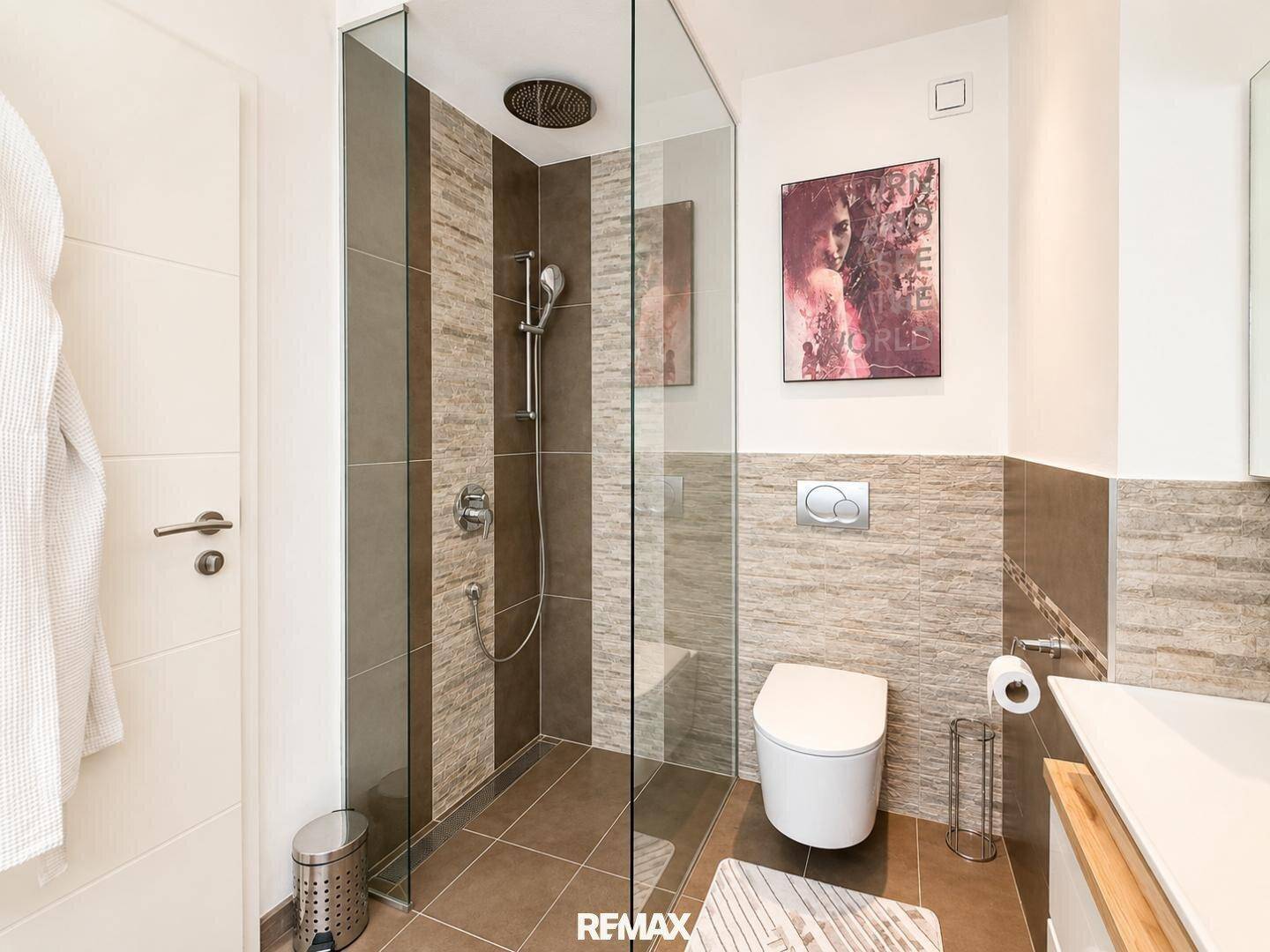 Modernes Badezimmer mit ebenerdiger Dusche, Wand-WC und stilvollen Fliesen.