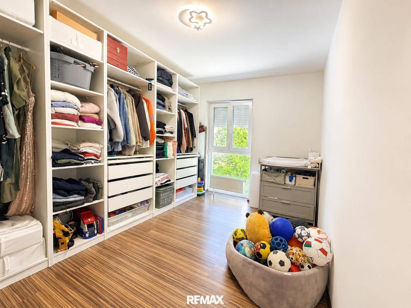 Geräumiger begehbarer Kleiderschrank mit viel Stauraum und Fenster, auch als Kinderzimmer nutzbar.