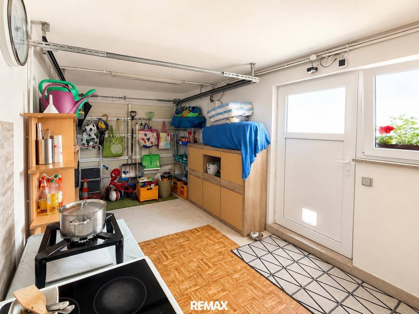Hauswirtschaftsraum mit Ausgang ins Freie, Regalen und Stauraum für diverse Gegenstände.