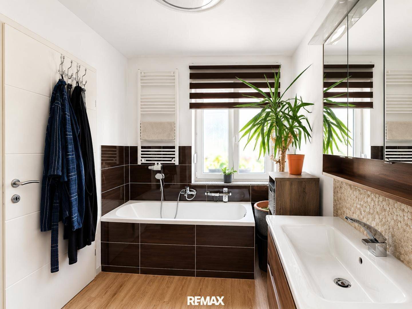 Modernes Badezimmer mit Badewanne, Einzelwaschbecken und Fenster für natürliche Belüftung.
