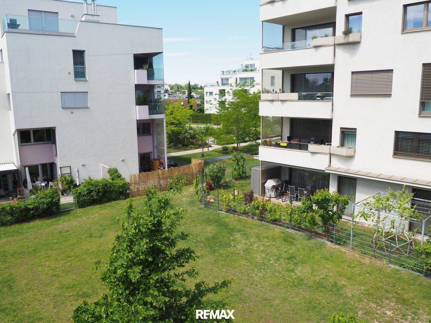 Moderne Wohngebäude umgeben von einer weitläufigen, grünen Parkanlage.