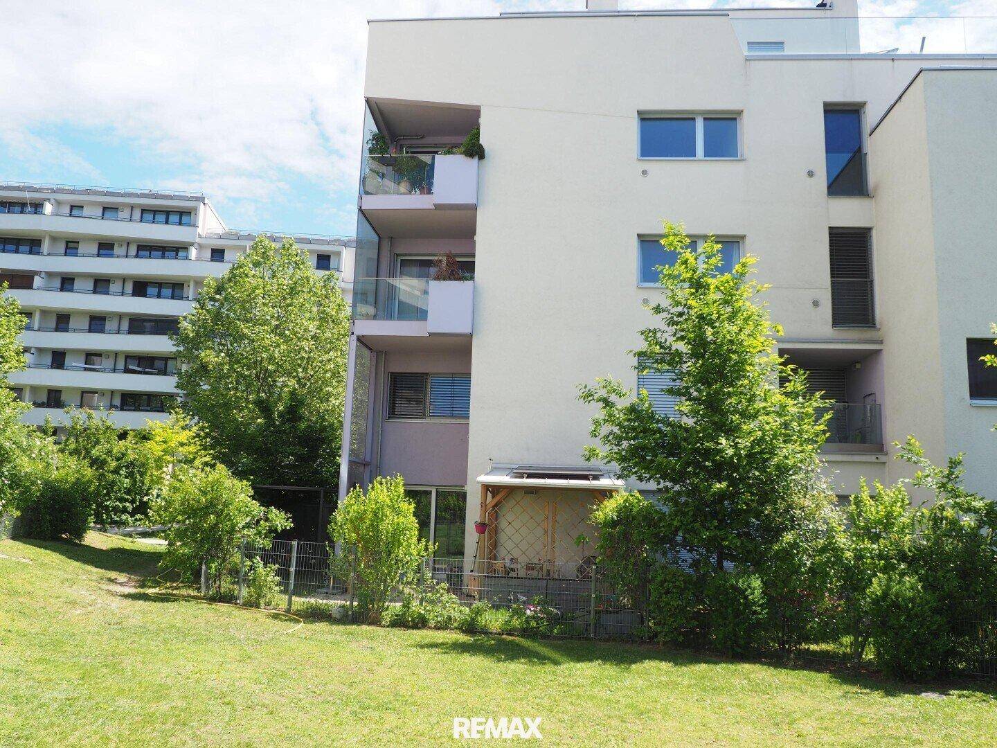 Moderne Wohnanlage mit Balkonen und Terrassen, umgeben von viel Grün.