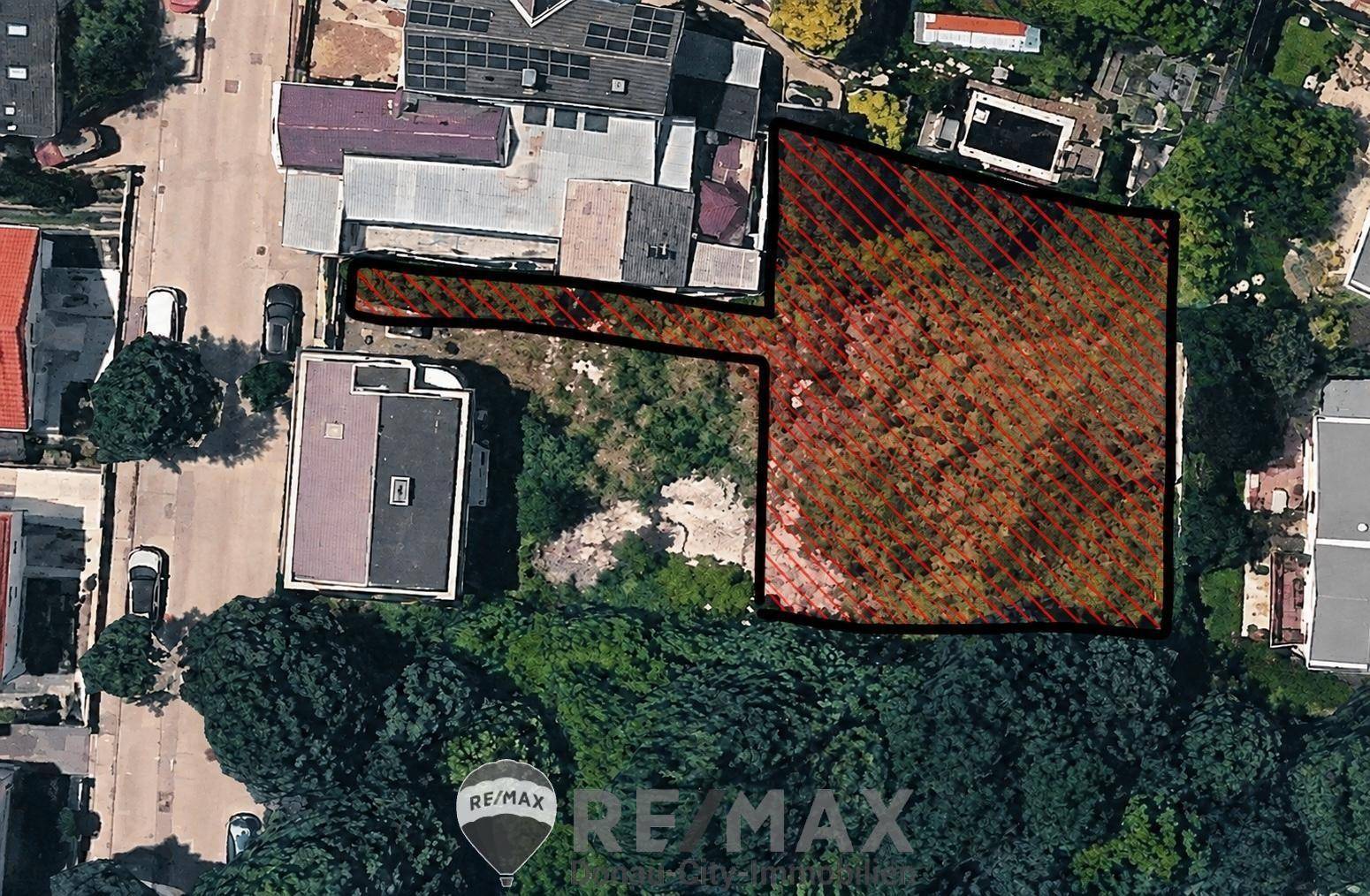 Luftaufnahme eines markierten Grundstücks mit umliegenden Häusern und viel Grünfläche.