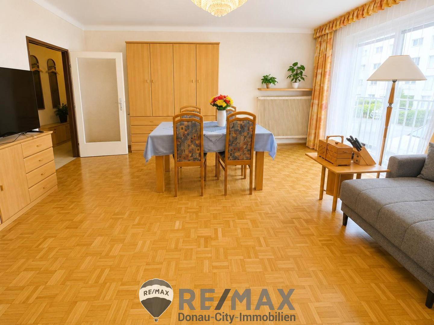 Geräumiger Wohn-Essbereich mit Parkettboden, Esstisch und Sofa, ideal für Familienleben.