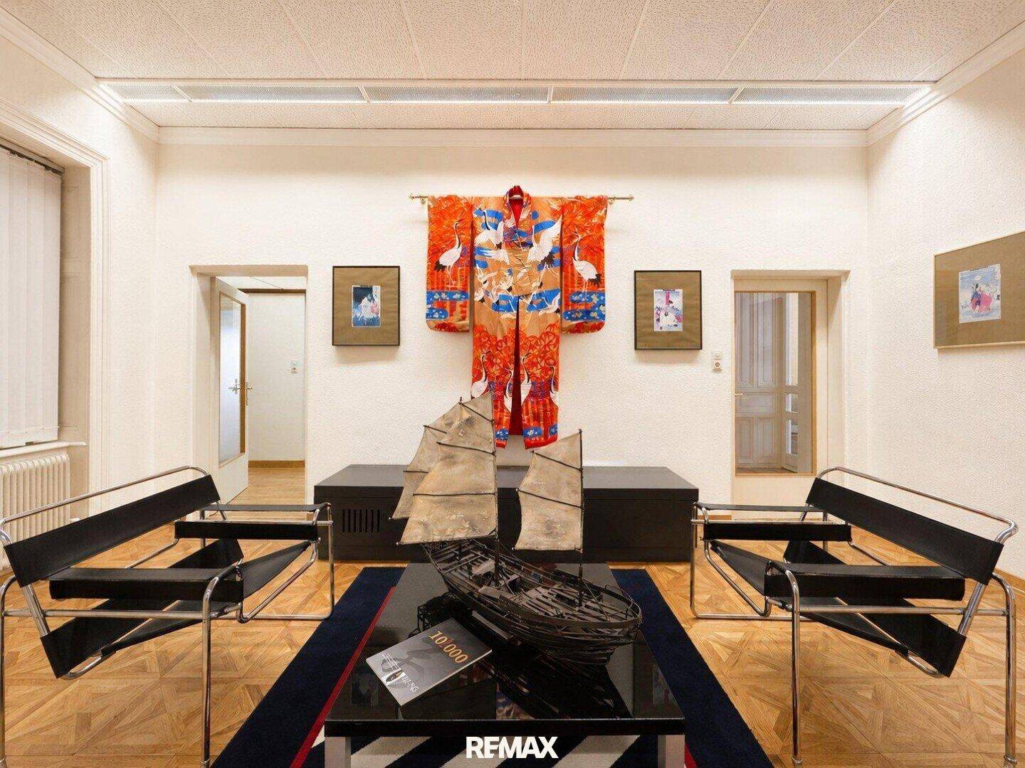 Lounge-Bereich mit modernen Sesseln, Holzboden und dekorativer Wandkunst.