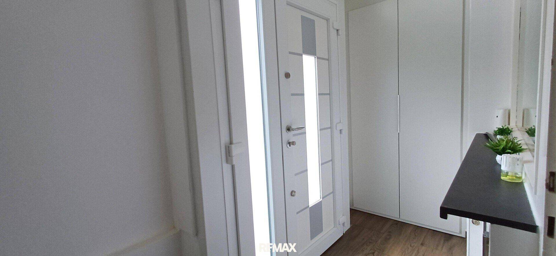 Eingangsbereich mit moderner Haustür und weißem Einbauschrank. Praktischer Stauraum für Garderobe.