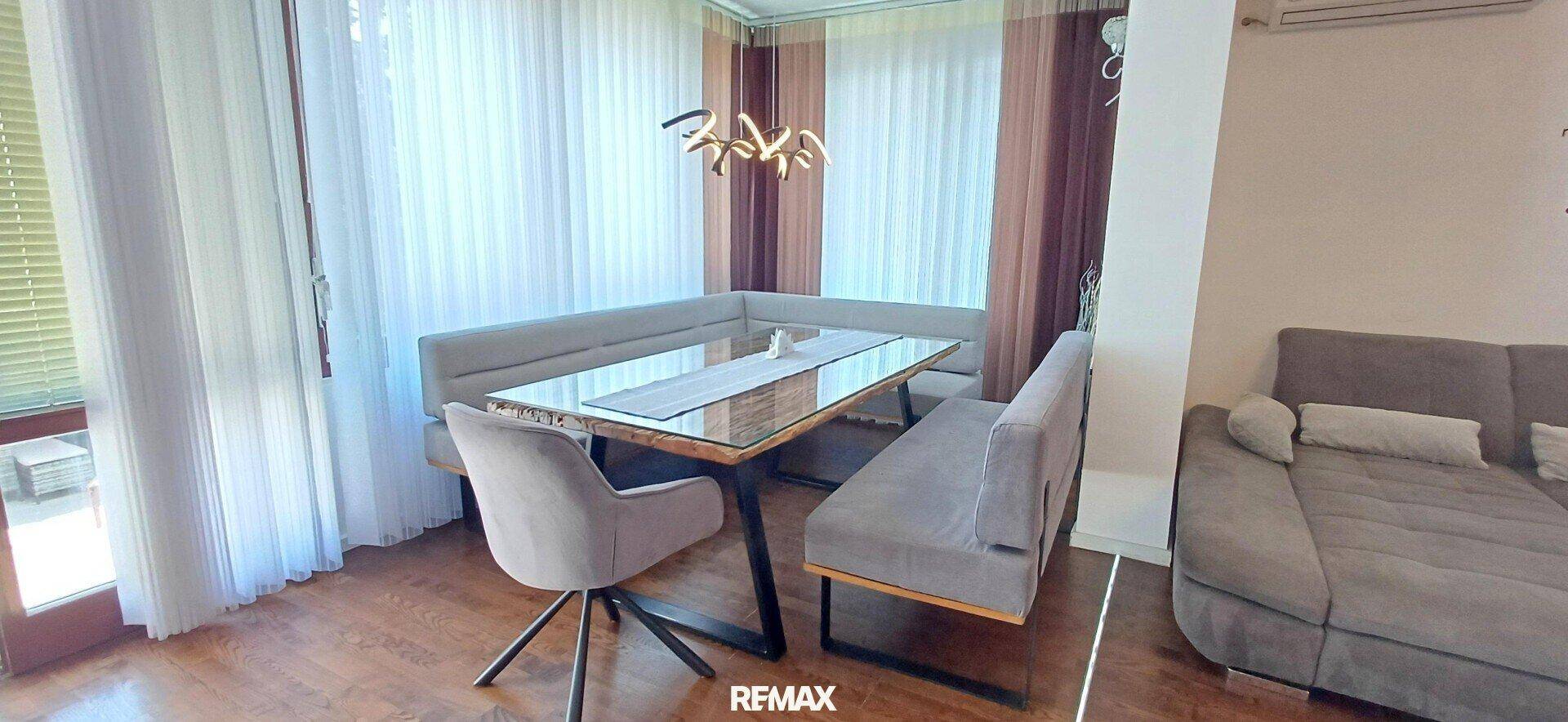 Heller Essbereich mit Holzboden, bequemer Eckbank und großem Esstisch am Fenster. Ideal für Familienessen.