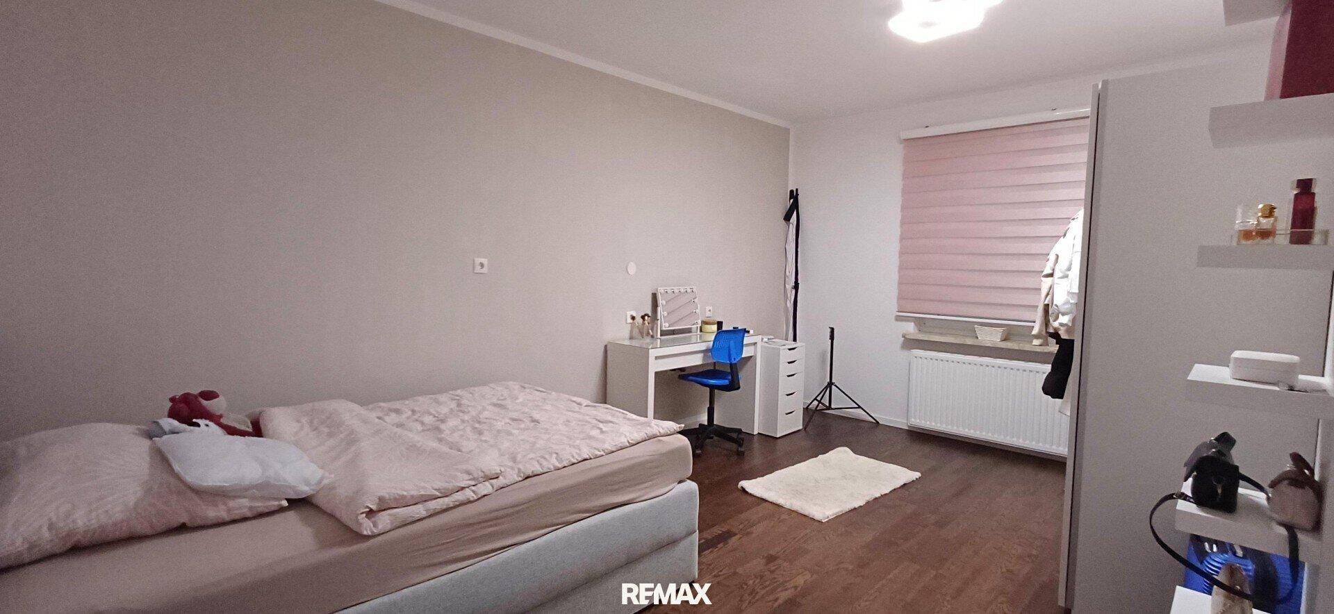 Helles Schlafzimmer mit Einzelbett, Schreibtisch und großem Kleiderschrank. Ideal für Kinder oder Gäste.