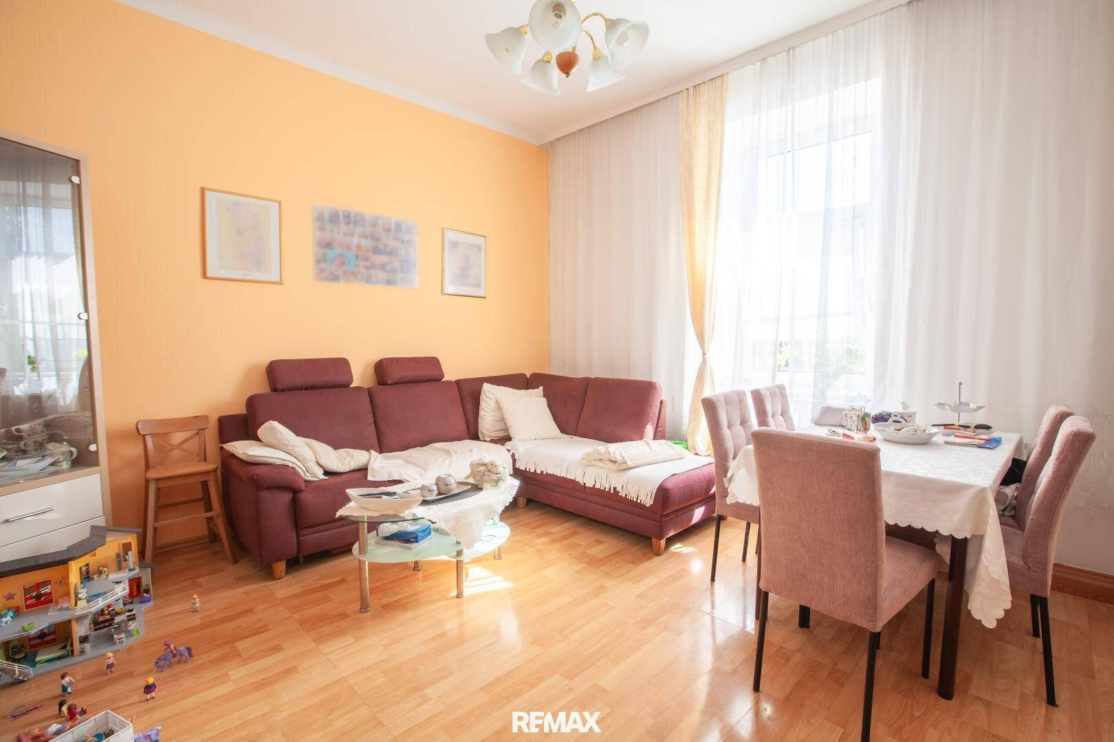Helles Wohn-Esszimmer mit gemütlichem Sofa, Esstisch und hellem Holzfußboden.