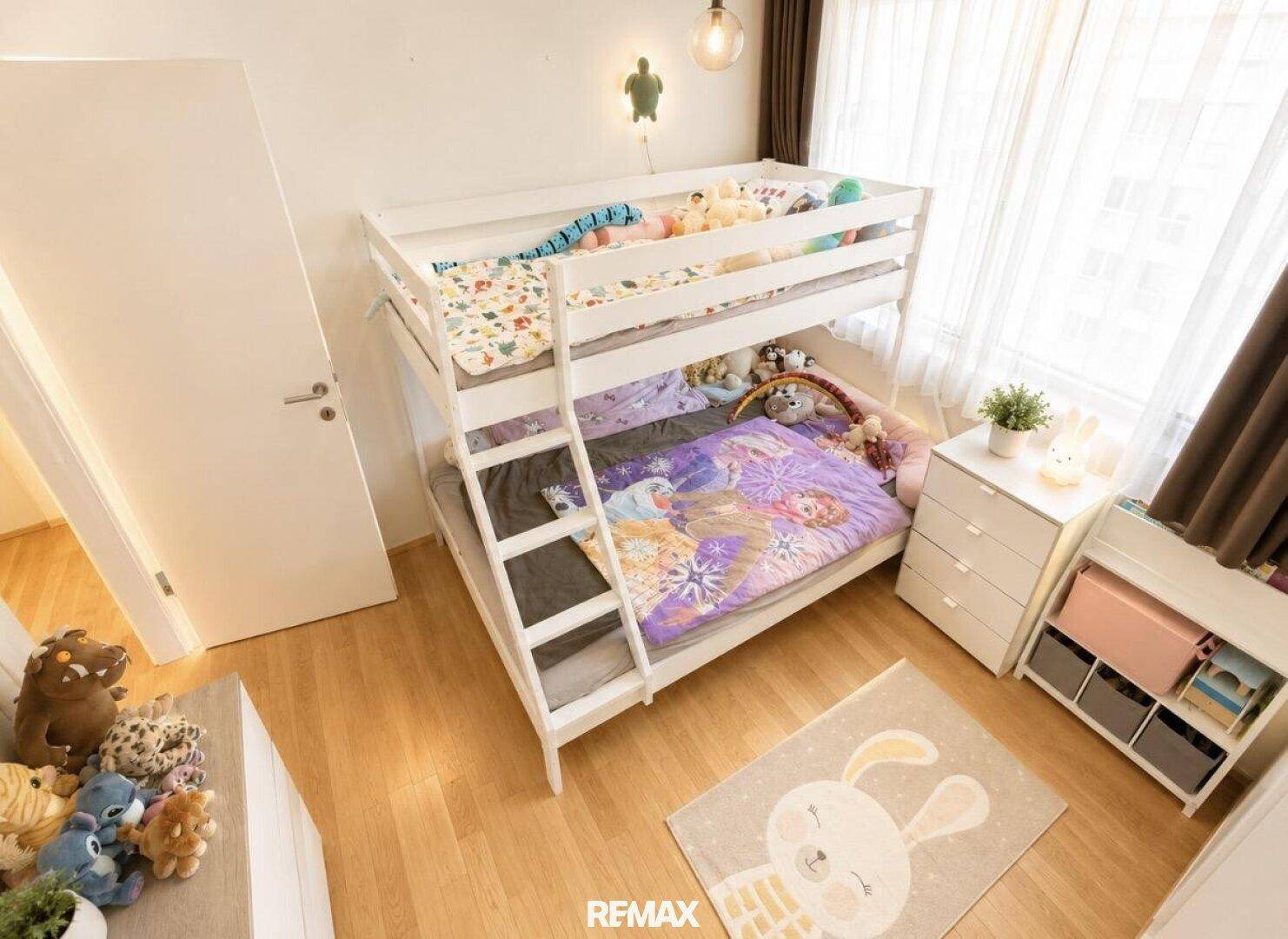 Kinderzimmer mit Etagenbett, Spielzeug und hellem Holzboden, ideal für Geschwister.