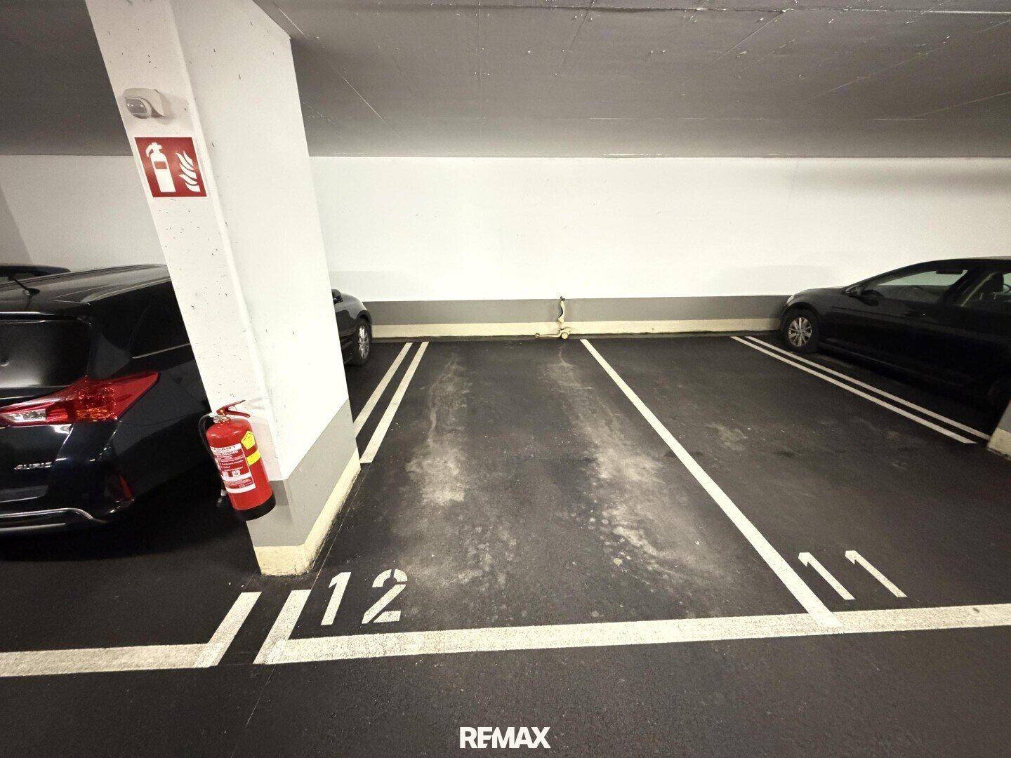 Zwei markierte Parkplätze in einer Tiefgarage, gut beleuchtet und zugänglich.