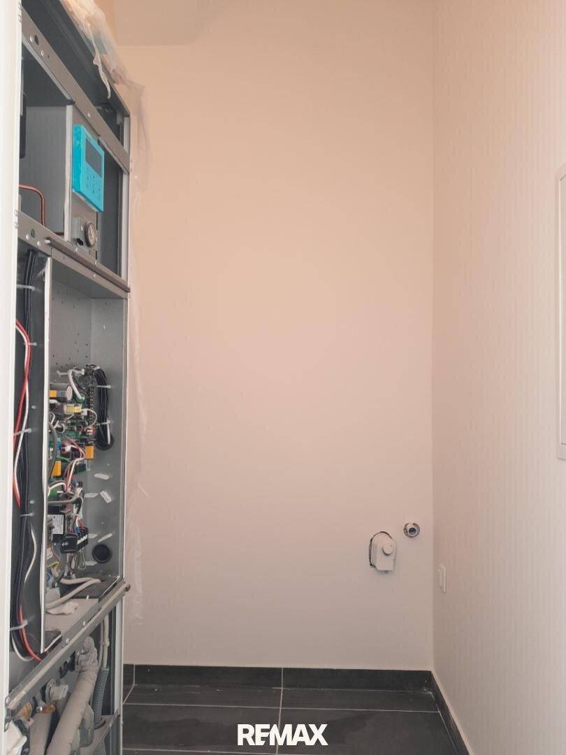 Hauswirtschaftsraum mit sichtbaren technischen Installationen und Anschlüssen.