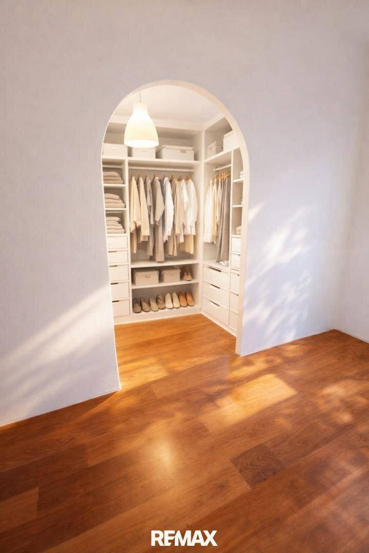 Begehbarer Kleiderschrank mit viel Stauraum und Regalen für Kleidung und Schuhe.