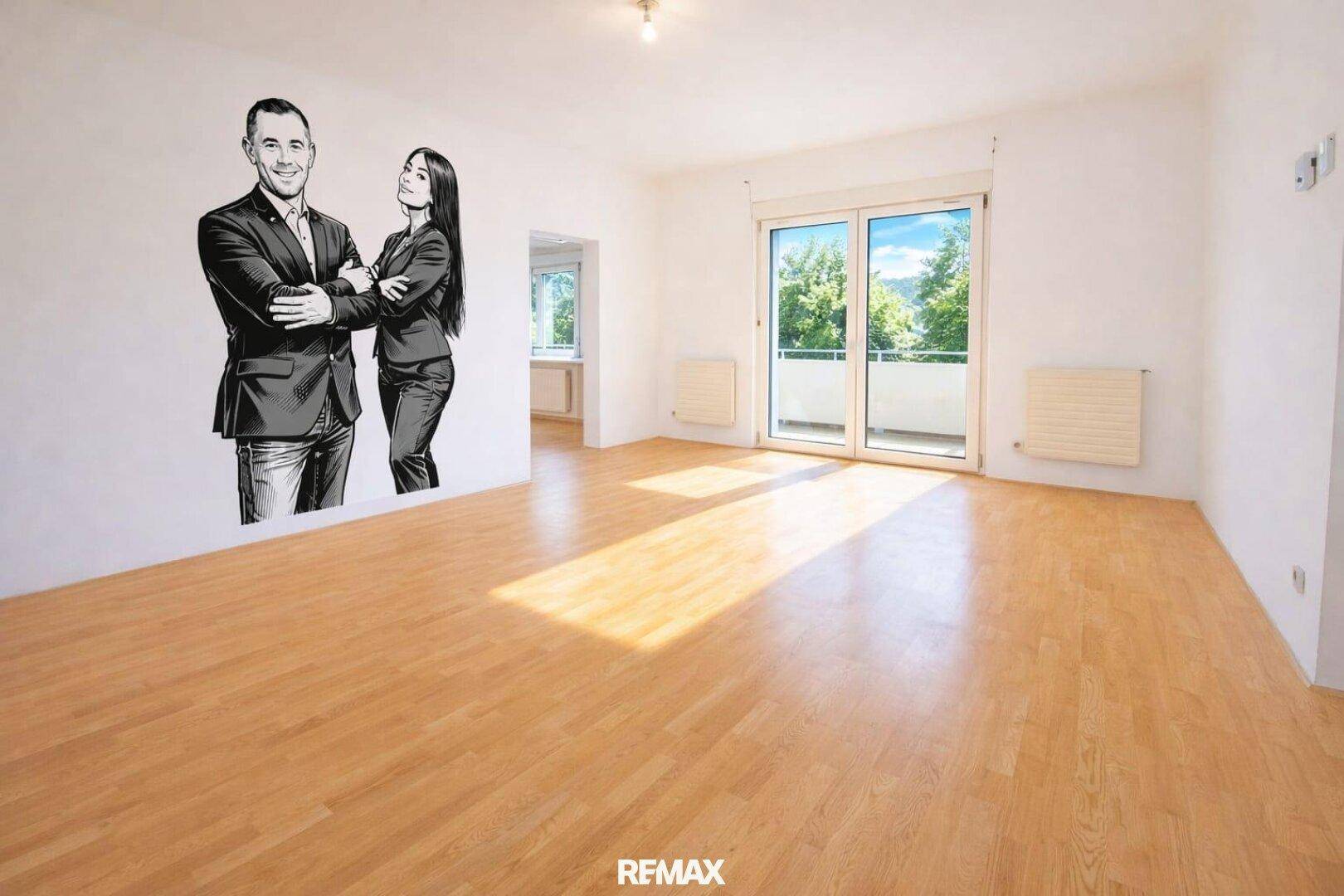 Leeres Wohnzimmer mit Holzboden und großen Fenstern, die auf einen Balkon führen.