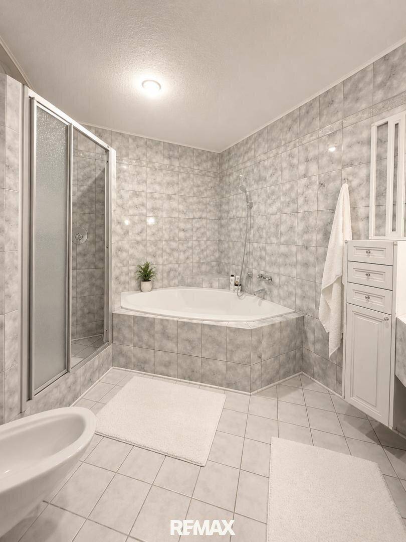 Geräumiges Badezimmer mit Eckbadewanne, Duschkabine und Bidet.