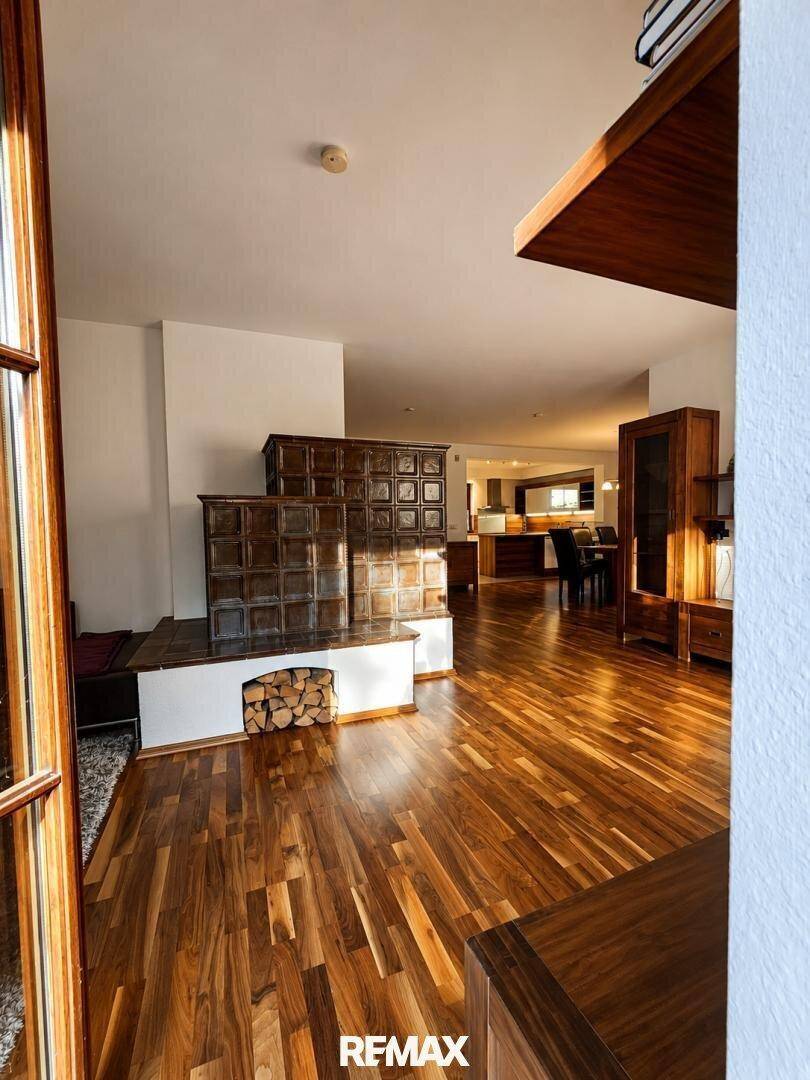 Gemütliches Wohnzimmer mit traditionellem Kachelofen und warmem Holzboden.