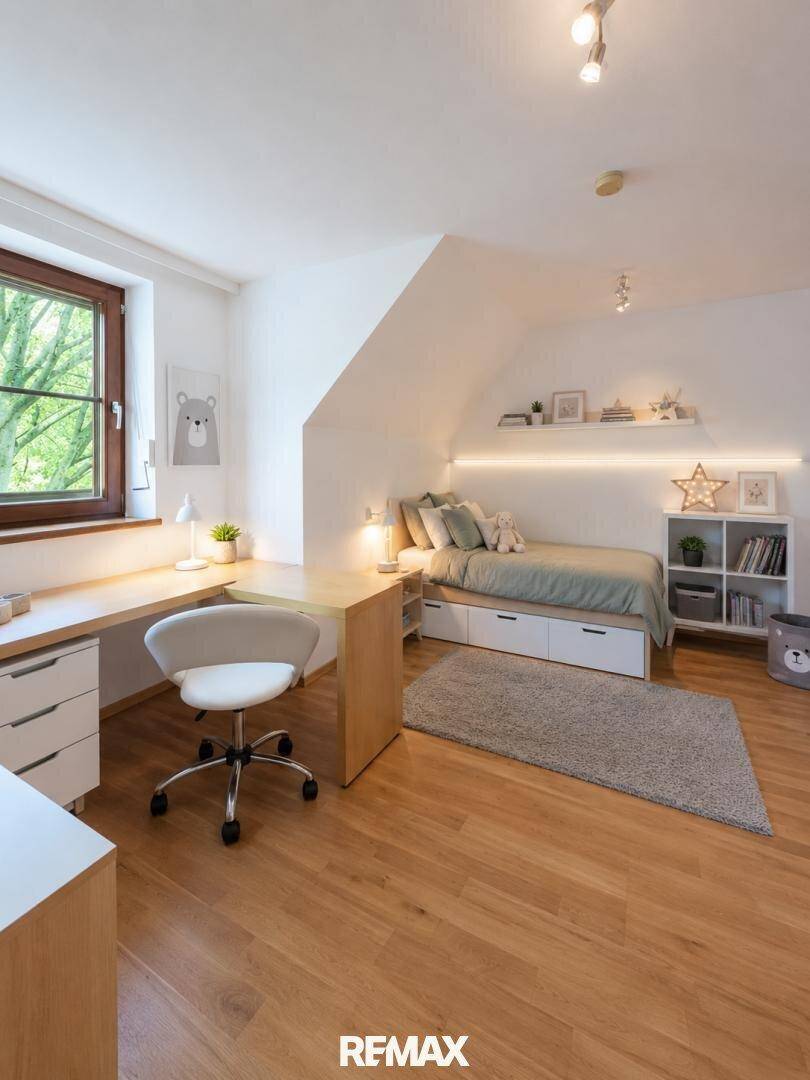 Helles Kinderzimmer mit Schreibtisch, Bett und Dachschräge, ideal zum Lernen und Schlafen.