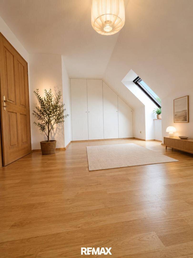 Geräumiges Schlafzimmer im Dachgeschoss mit Einbauschränken und Dachfenster.