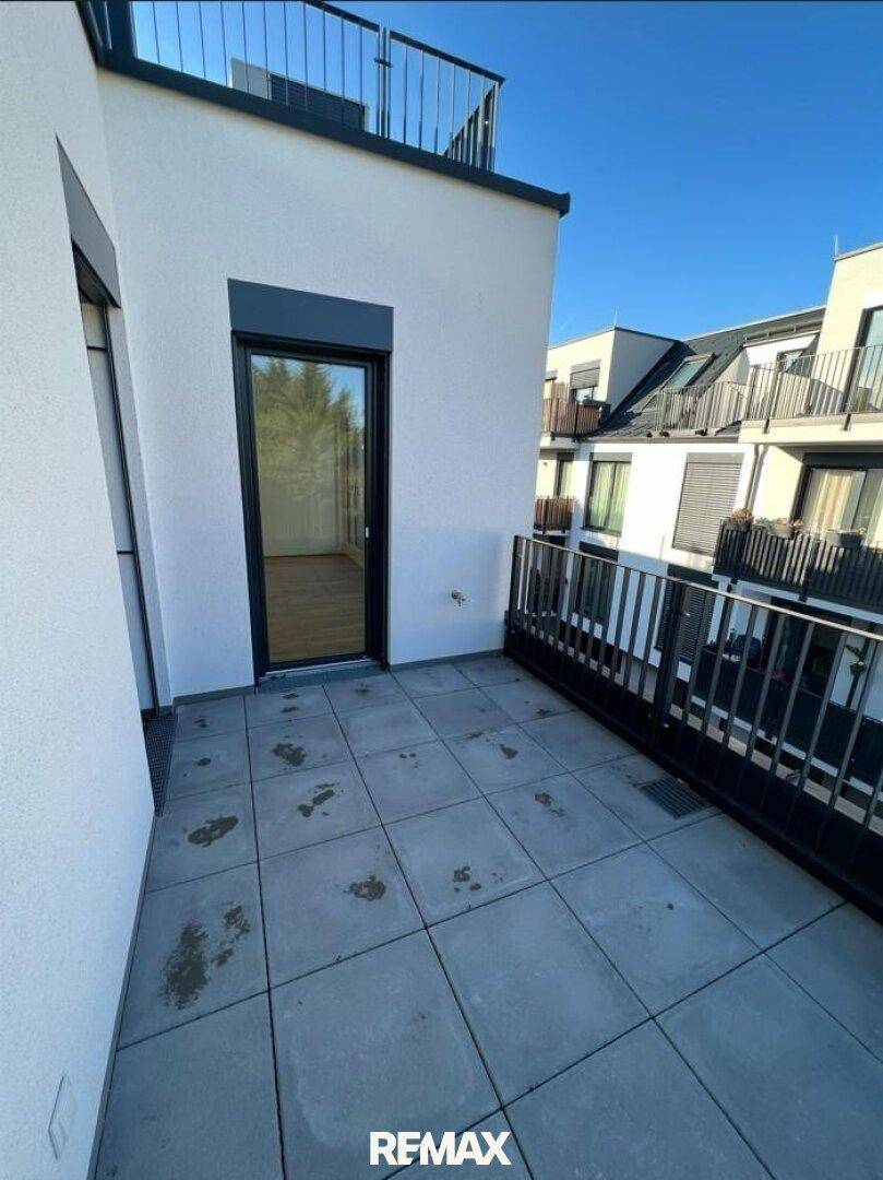 Geräumiger, unmöblierter Balkon mit Fliesenboden und Geländer, bietet Platz für individuelle Gestaltung.