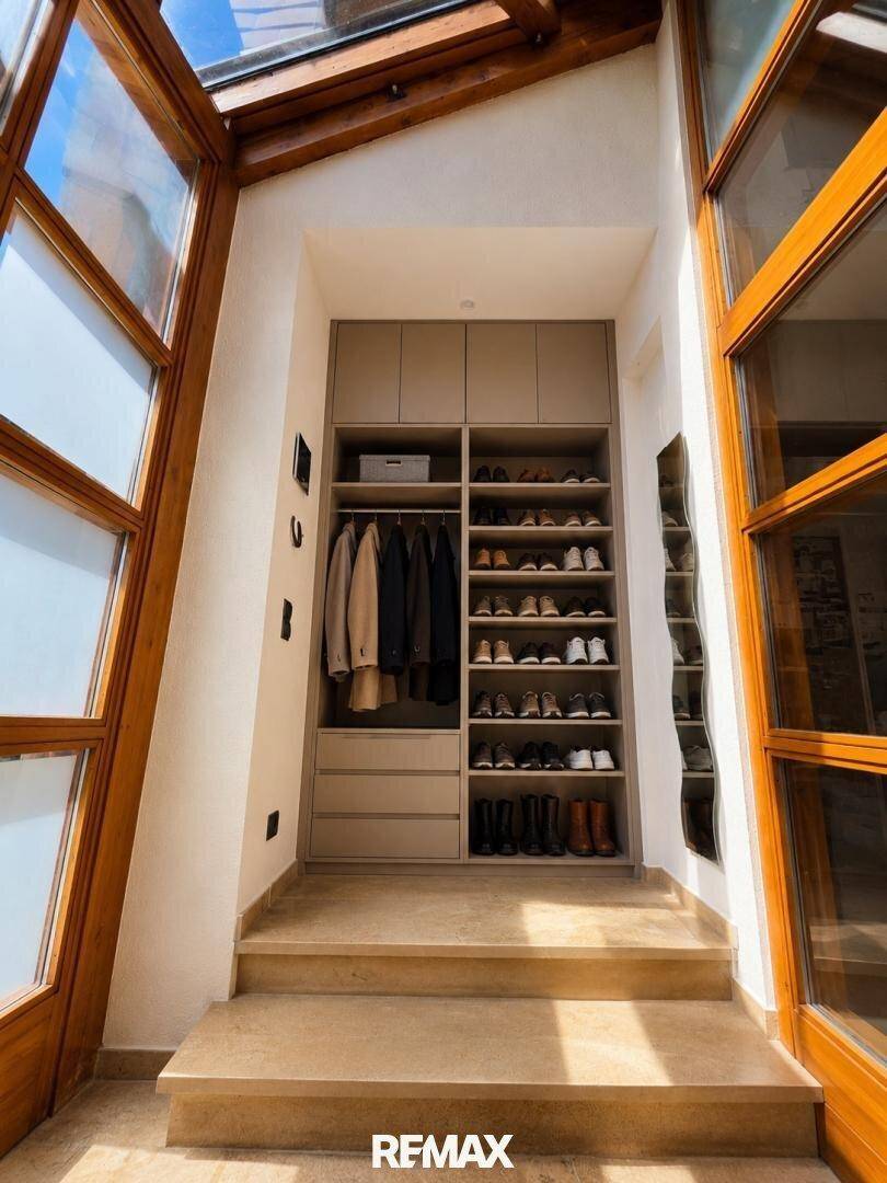 Heller Flur mit integriertem Kleiderschrank und Schuhregalen, verbunden mit dem Wintergarten.