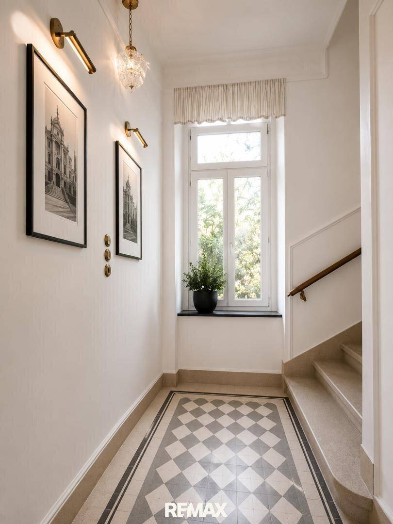 Heller Flur mit elegantem Schachbrettmuster-Fliesenboden, hohen Decken und einem Fenster mit Blick ins Grüne.