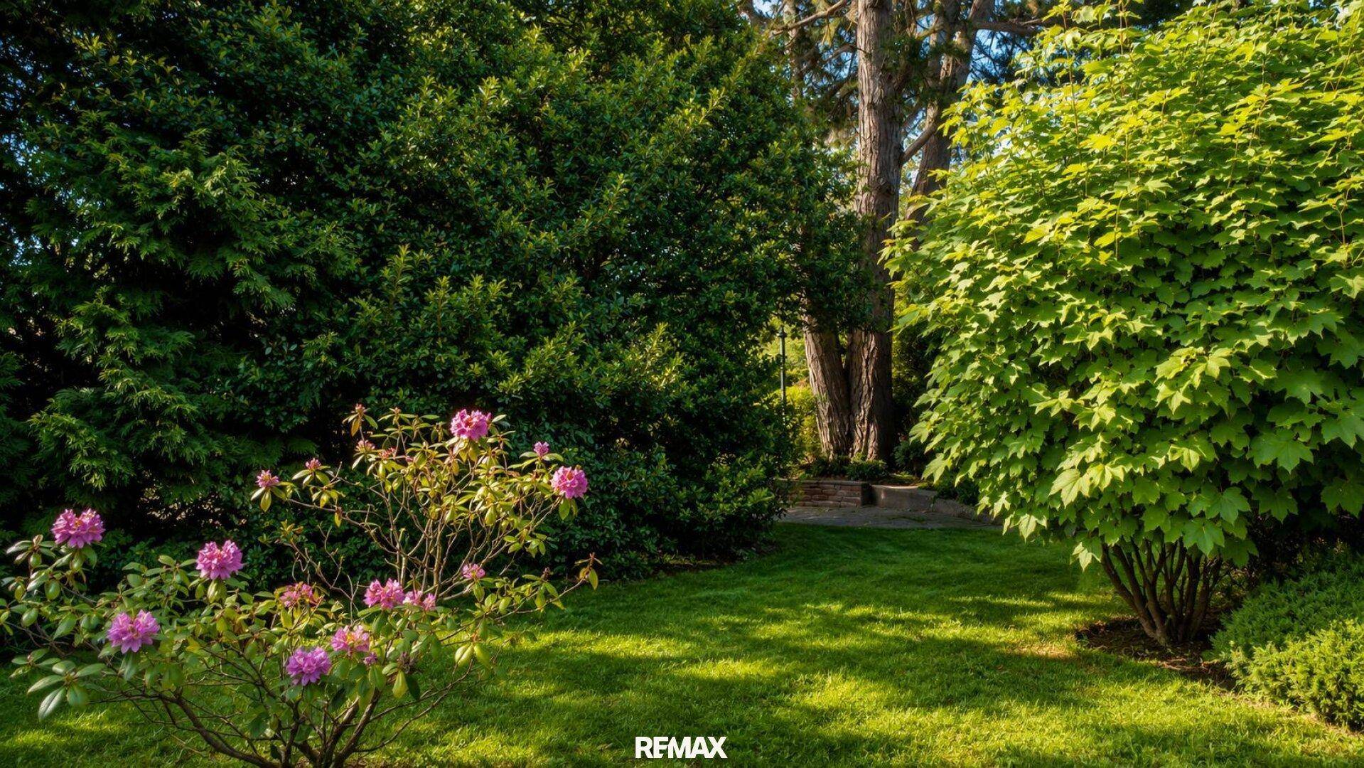 Gepflegter Garten mit üppigem Grün, blühenden Sträuchern und hohen Bäumen im Sonnenlicht.