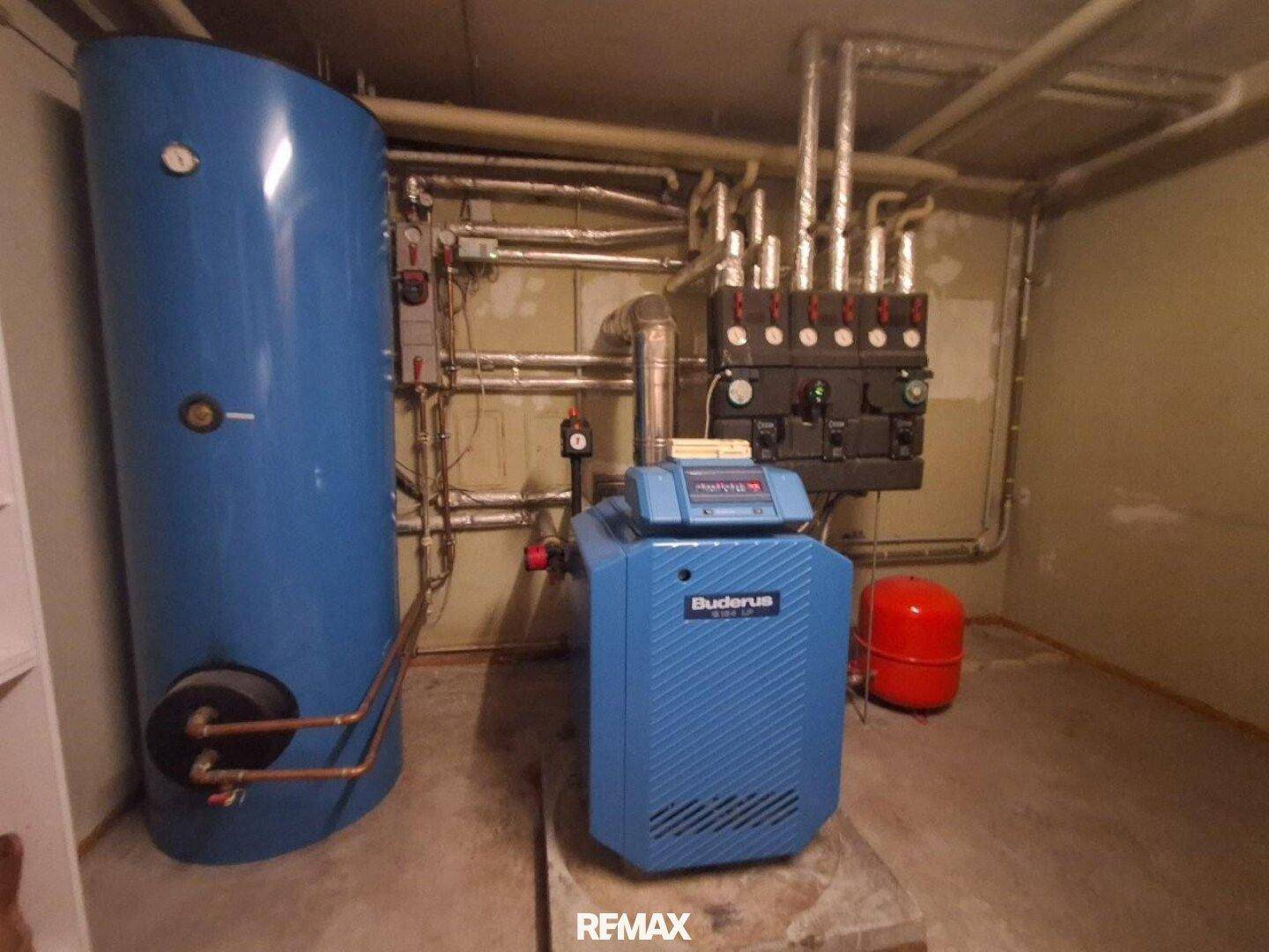 Heizungsraum mit Buderus-Heizkessel und Warmwasserspeicher in blau.