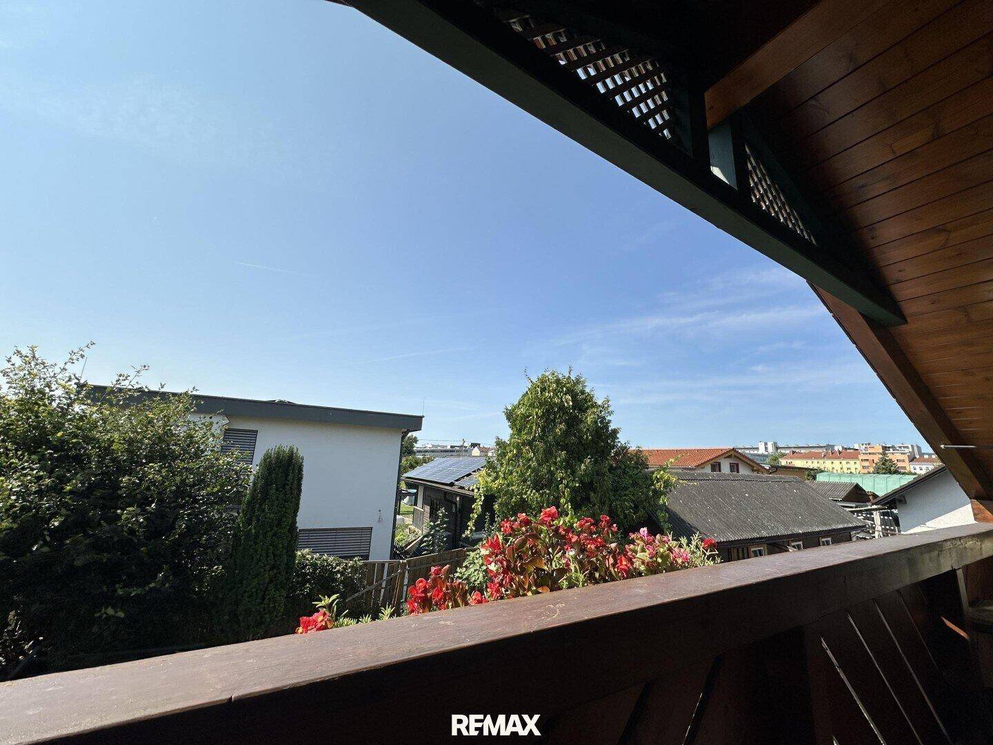 Blick vom Balkon auf die umliegende Nachbarschaft und den blauen Himmel.