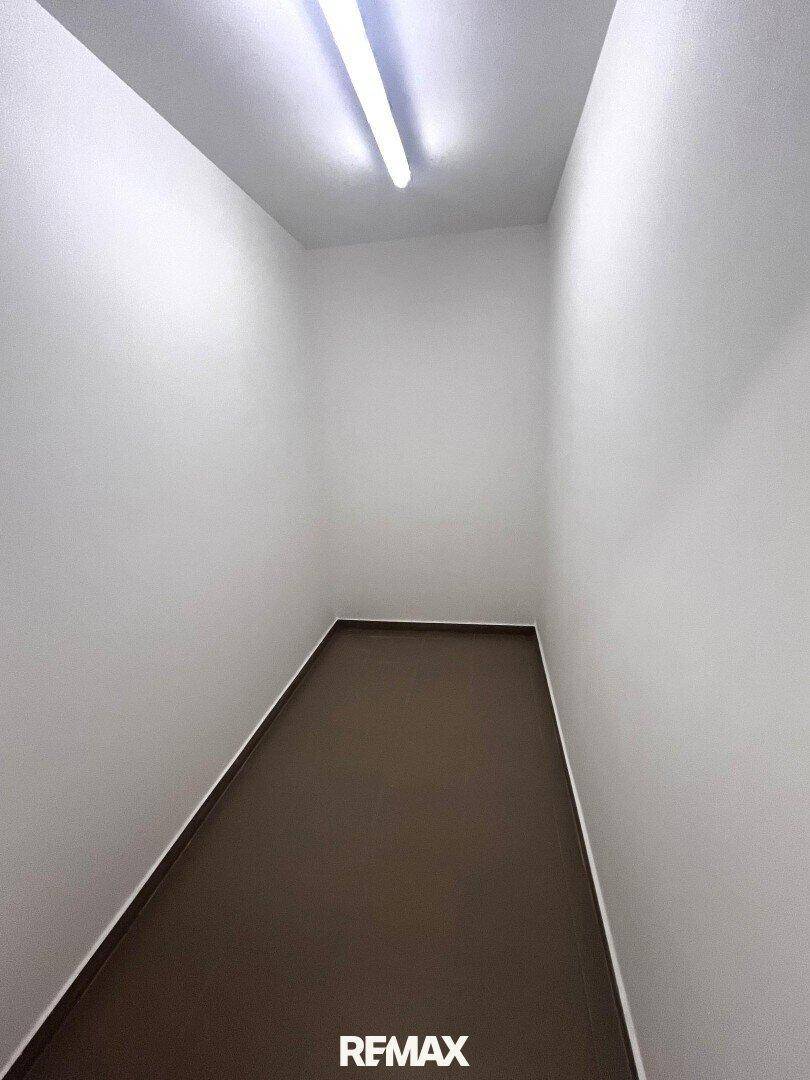 Kleiner, leerer Abstellraum mit weißen Wänden und dunklem Boden, ideal für zusätzlichen Stauraum.