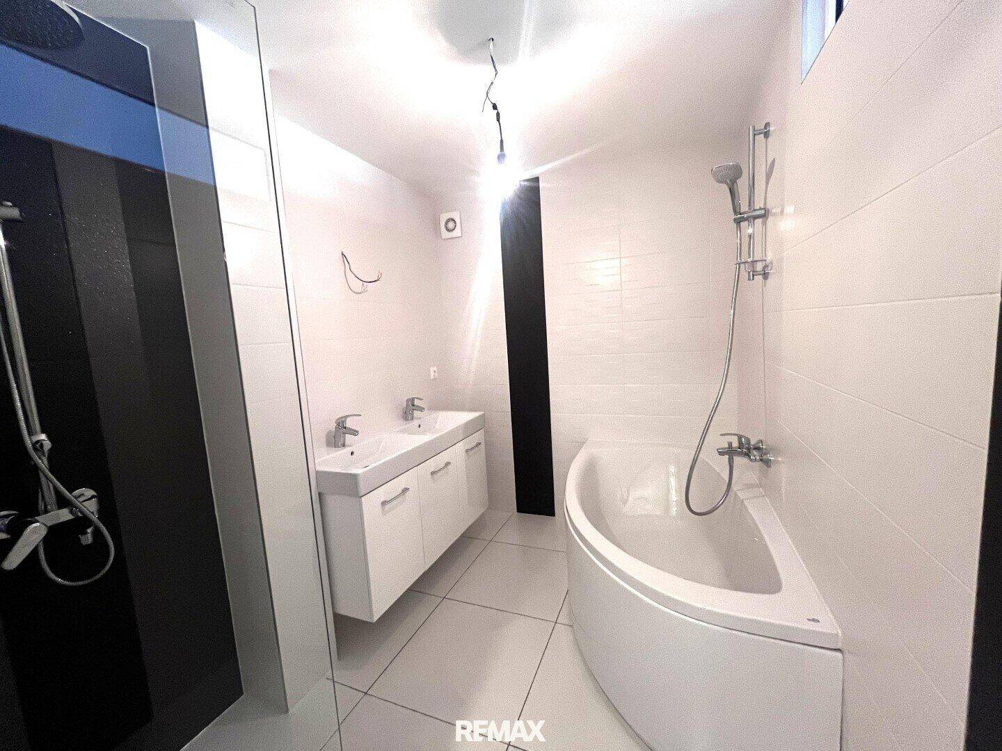 Modernes Badezimmer mit Doppelwaschbecken, Badewanne und separater Dusche.