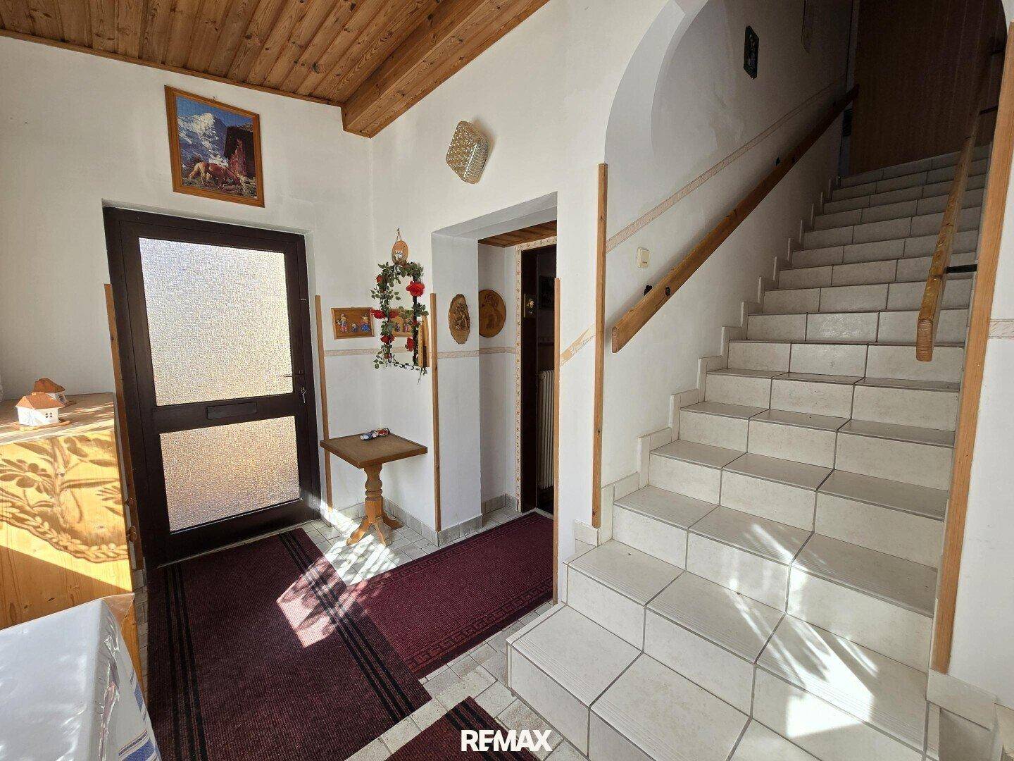 Eingangsbereich mit gefliestem Boden und Treppe zum Obergeschoss.