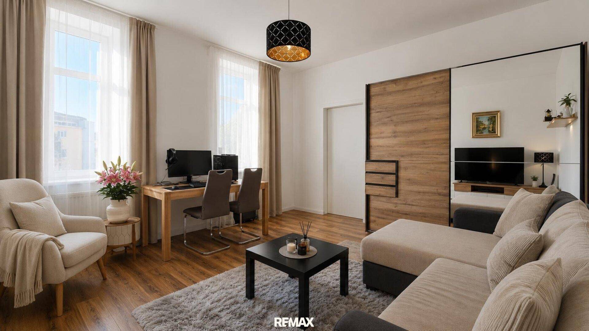 Geräumiges Wohnzimmer mit großem Sofa, Holzboden und viel Tageslicht durch die Fenster.