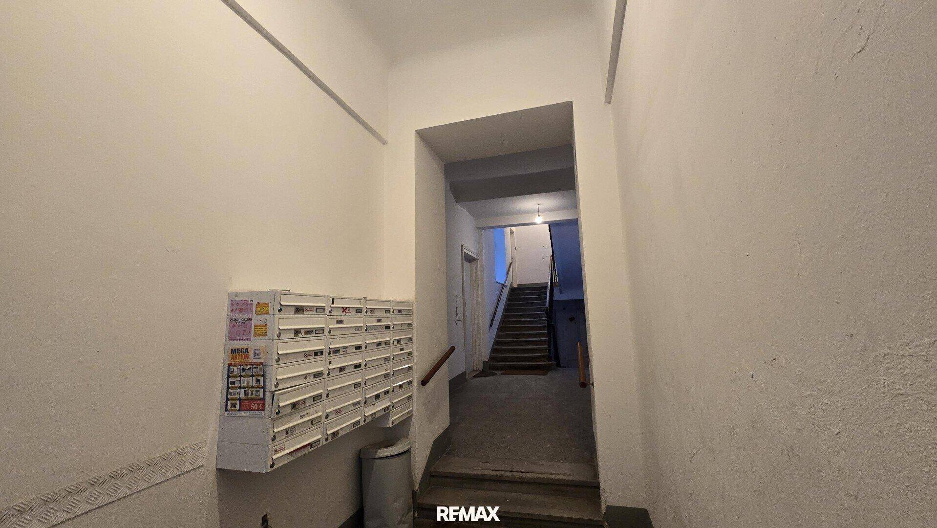 Eingangsbereich eines Altbaus mit Briefkästen und Treppenhaus.
