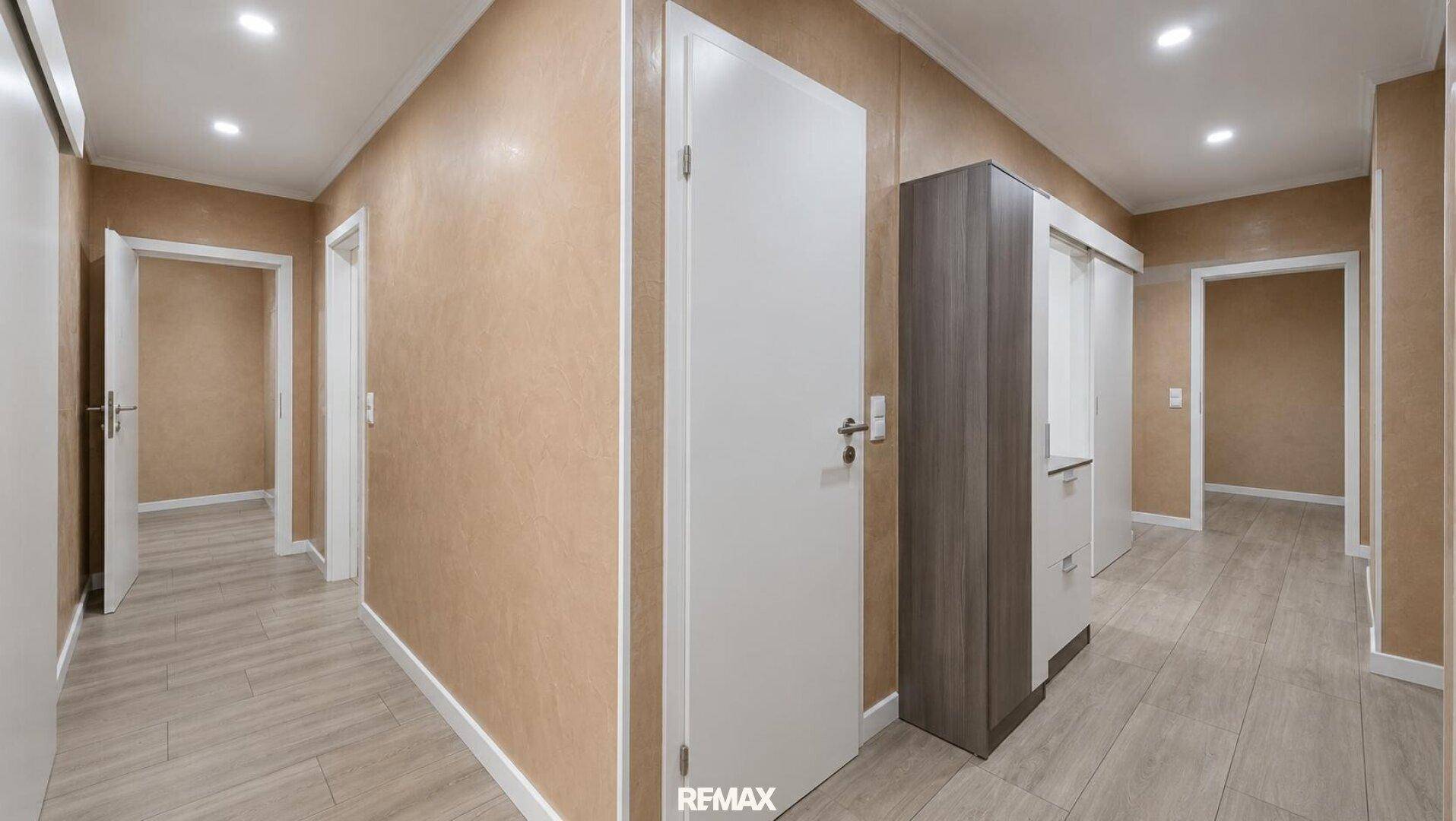 Heller Flur mit mehreren Türen, Einbauschrank und modernem Holzboden.