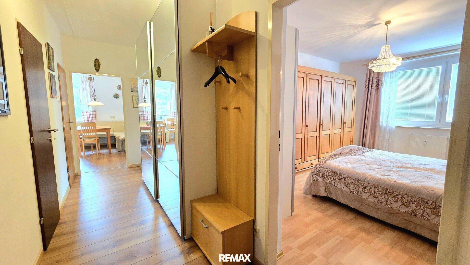 Flur mit Garderobe und Laminatboden, der den Zugang zum Schlafzimmer ermöglicht.