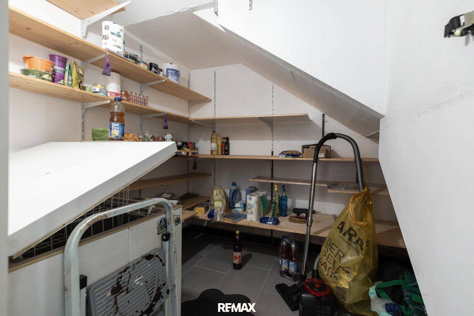 Praktischer Abstellraum unter der Treppe mit vielen Regalen für Vorräte.