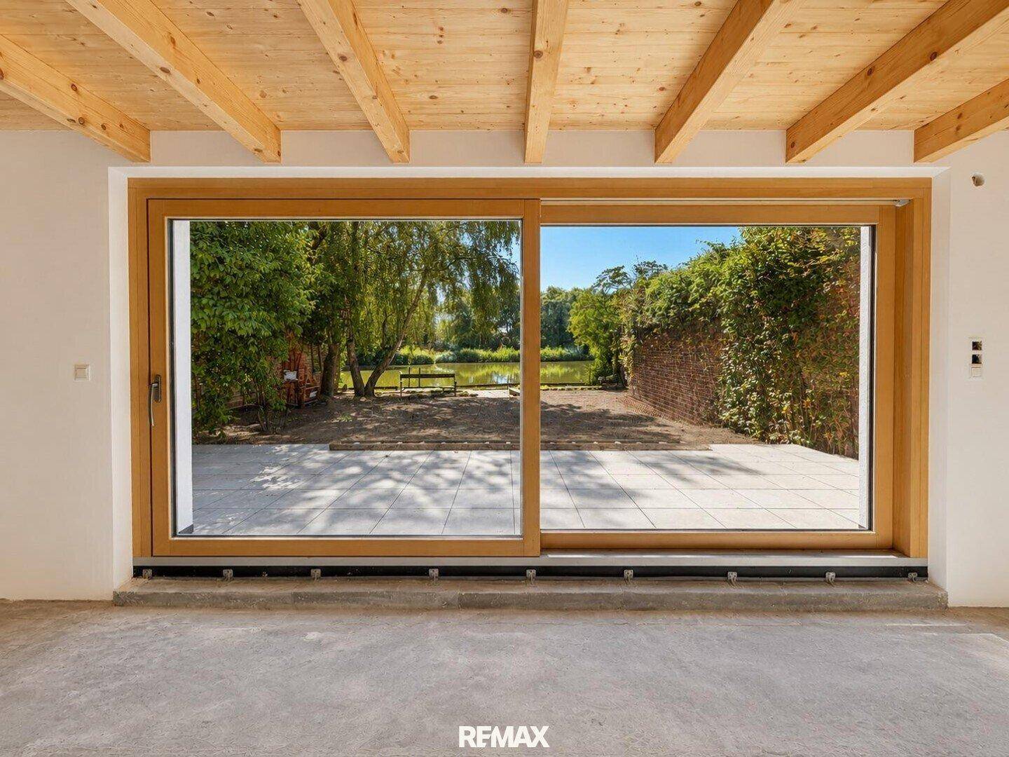 Große Schiebetüren bieten einen weiten Blick auf die Terrasse und den grünen Gartenbereich.