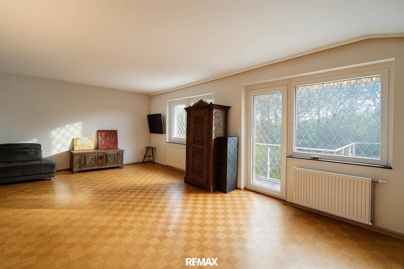 Gemütliches Wohnzimmer mit Parkettboden, traditionellen Möbeln und Zugang zu einem französischen Balkon.