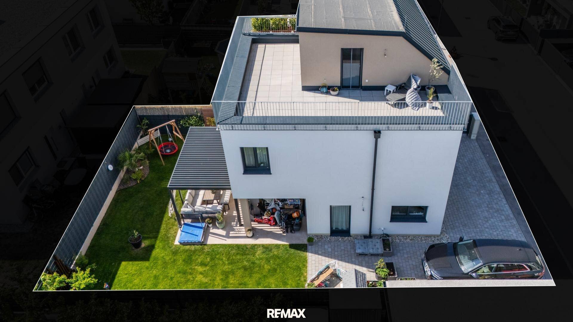 Vogelperspektive des modernen Hauses mit Garten, Terrasse und Dachterrasse.