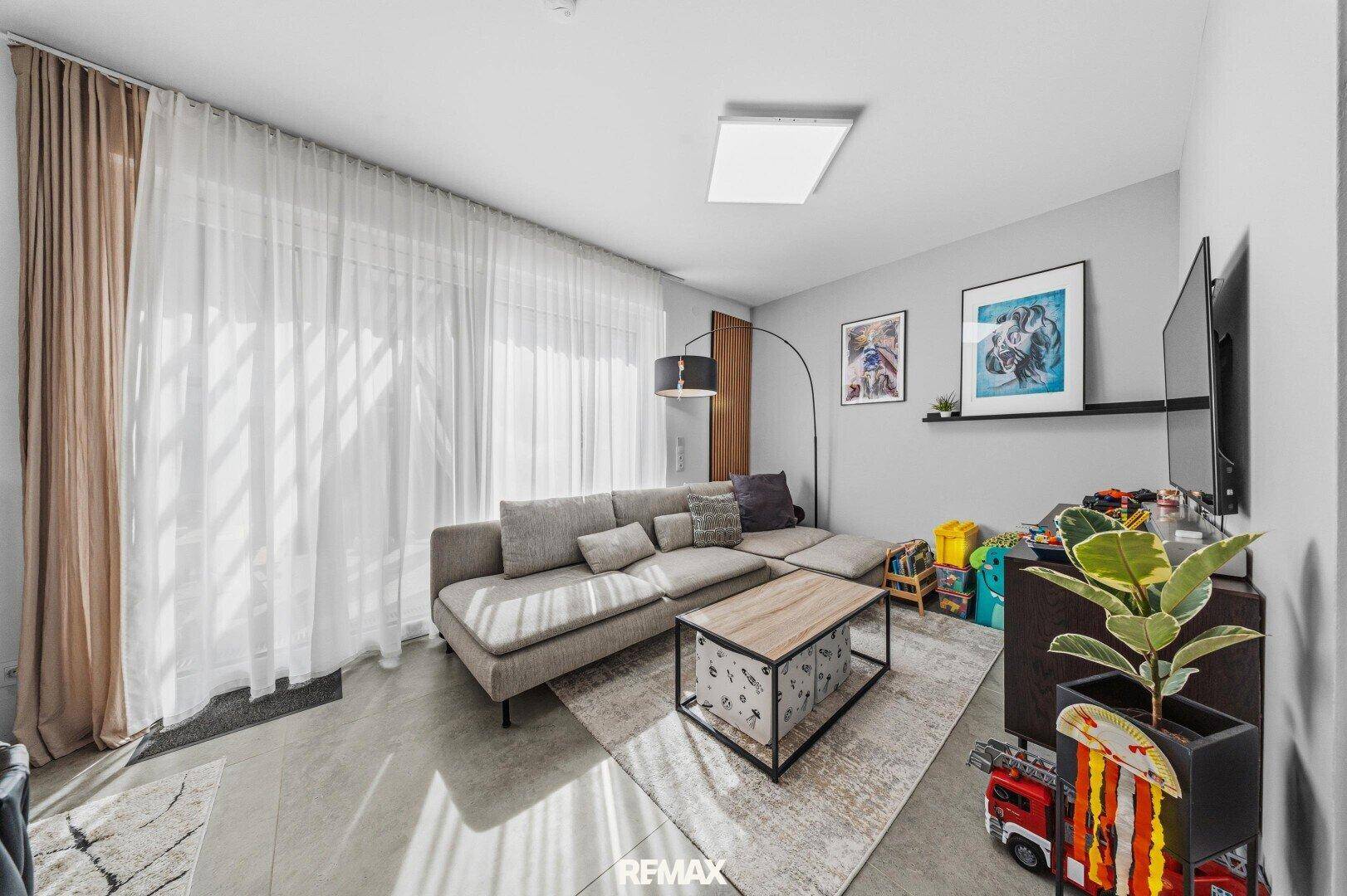 Gemütliches Wohnzimmer mit großer Eckcouch, modernem Couchtisch und viel Tageslicht.