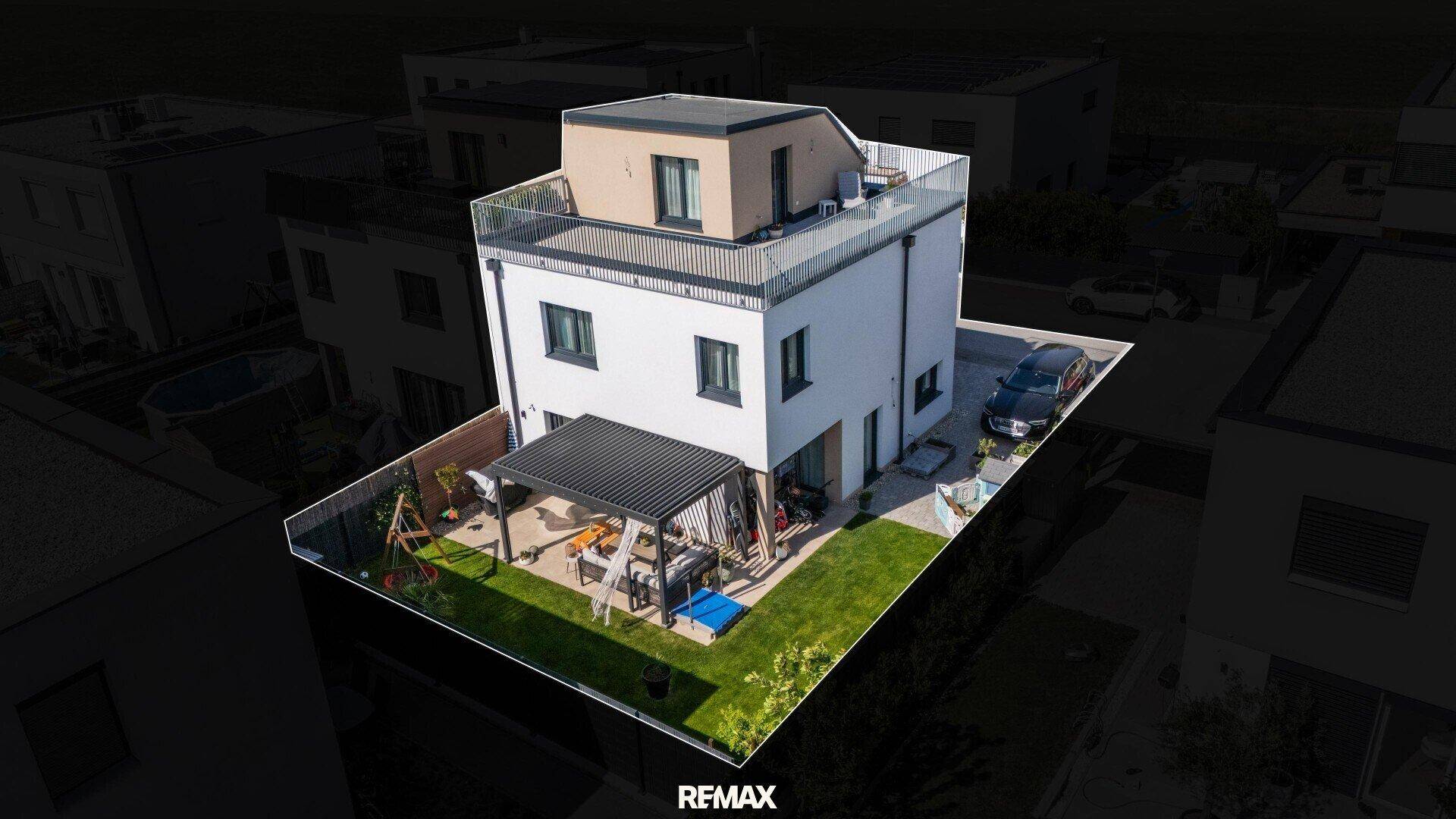 Ansicht des modernen Hauses von oben mit gepflegtem Garten, Terrasse und Dachterrasse.