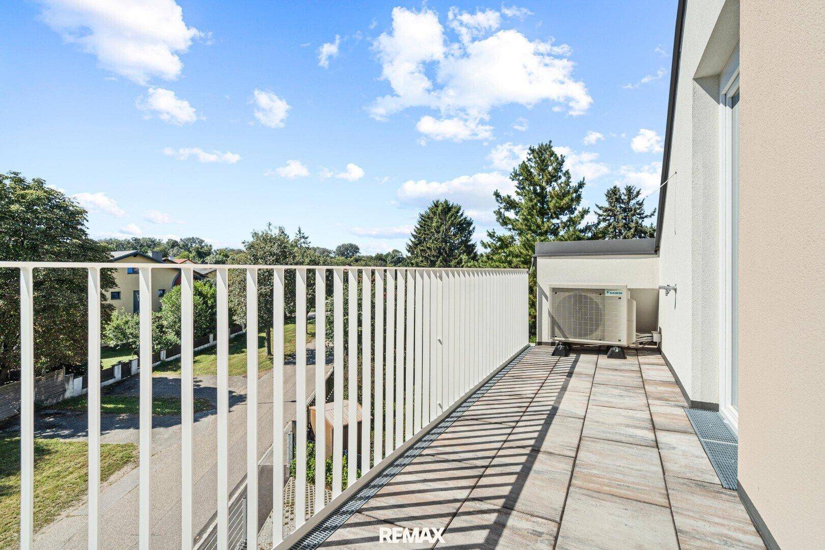 Großer Balkon mit Fliesenboden und weitem Blick in die Umgebung.