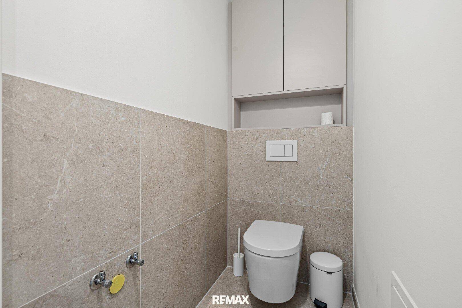 Separates Gäste-WC mit Wand-WC und Fliesenboden.