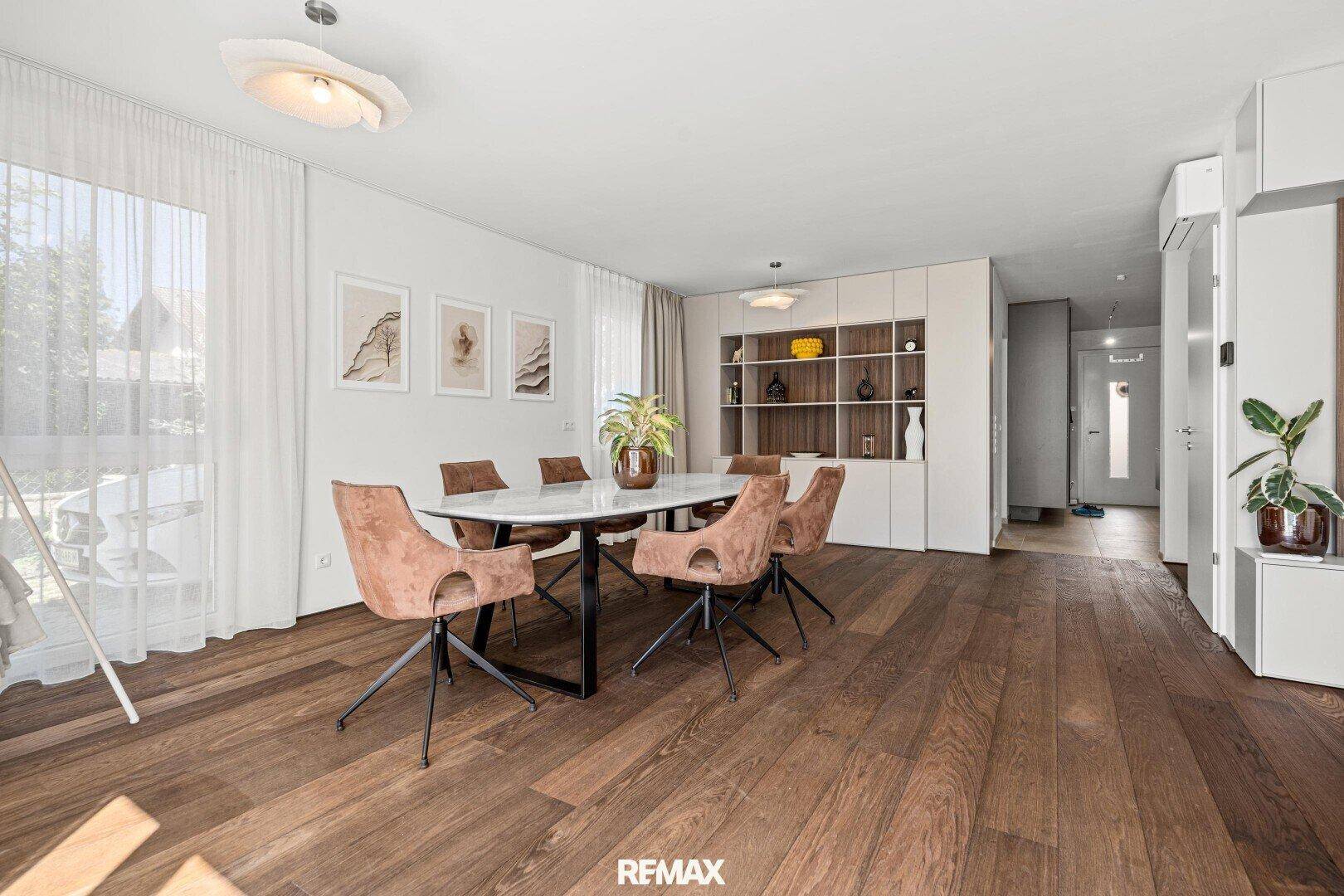Moderner Essbereich mit Holzboden und integriertem Regal, offen zum Flur.