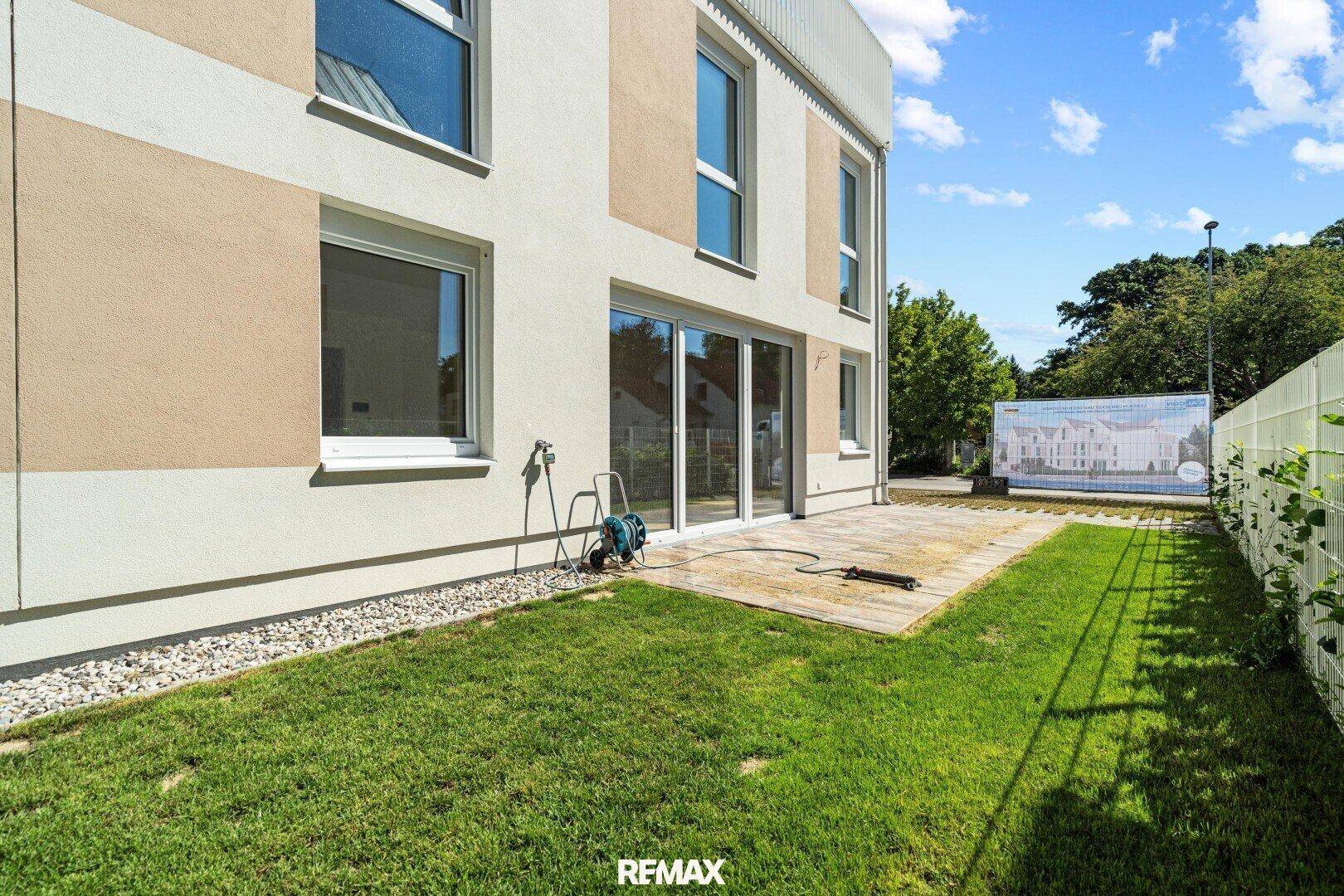 Privater Gartenbereich mit Rasenfläche und Terrasse, ideal für Entspannung im Freien.