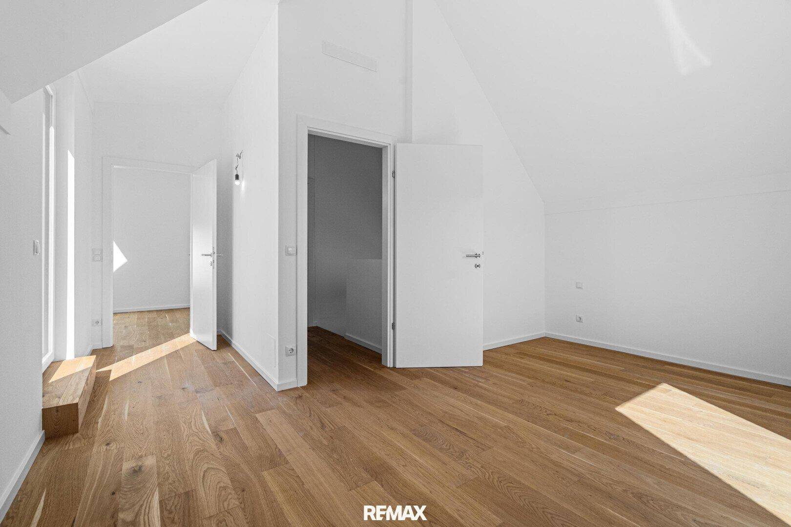 Geräumiges Zimmer im Dachgeschoss mit Eichenparkett und schrägen Wänden, bietet viel Potenzial.