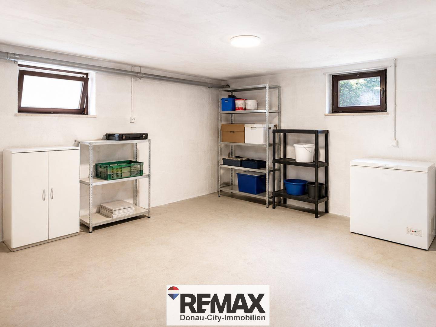 Geräumiger Lagerraum im Keller mit Regalen, Gefriertruhe und zwei Fenstern.