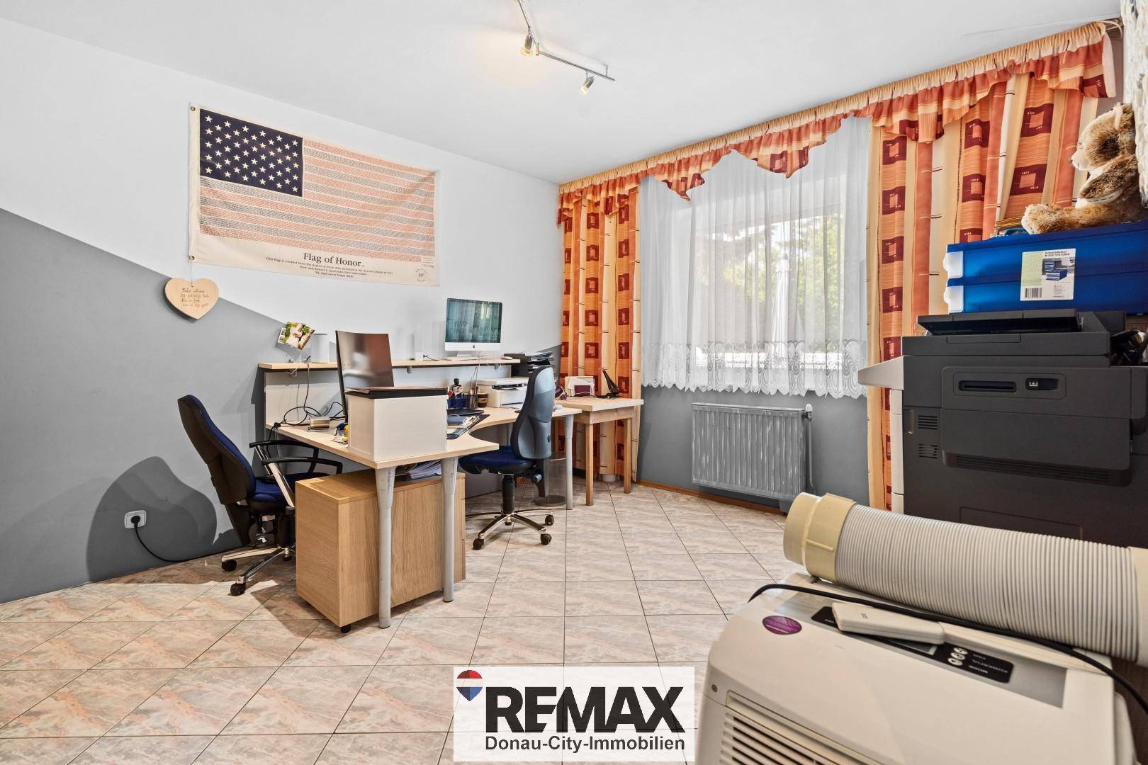 Geräumiges Arbeitszimmer mit Fliesenboden, Schreibtischen und Fenster, ideal für Home-Office-Tätigkeiten.